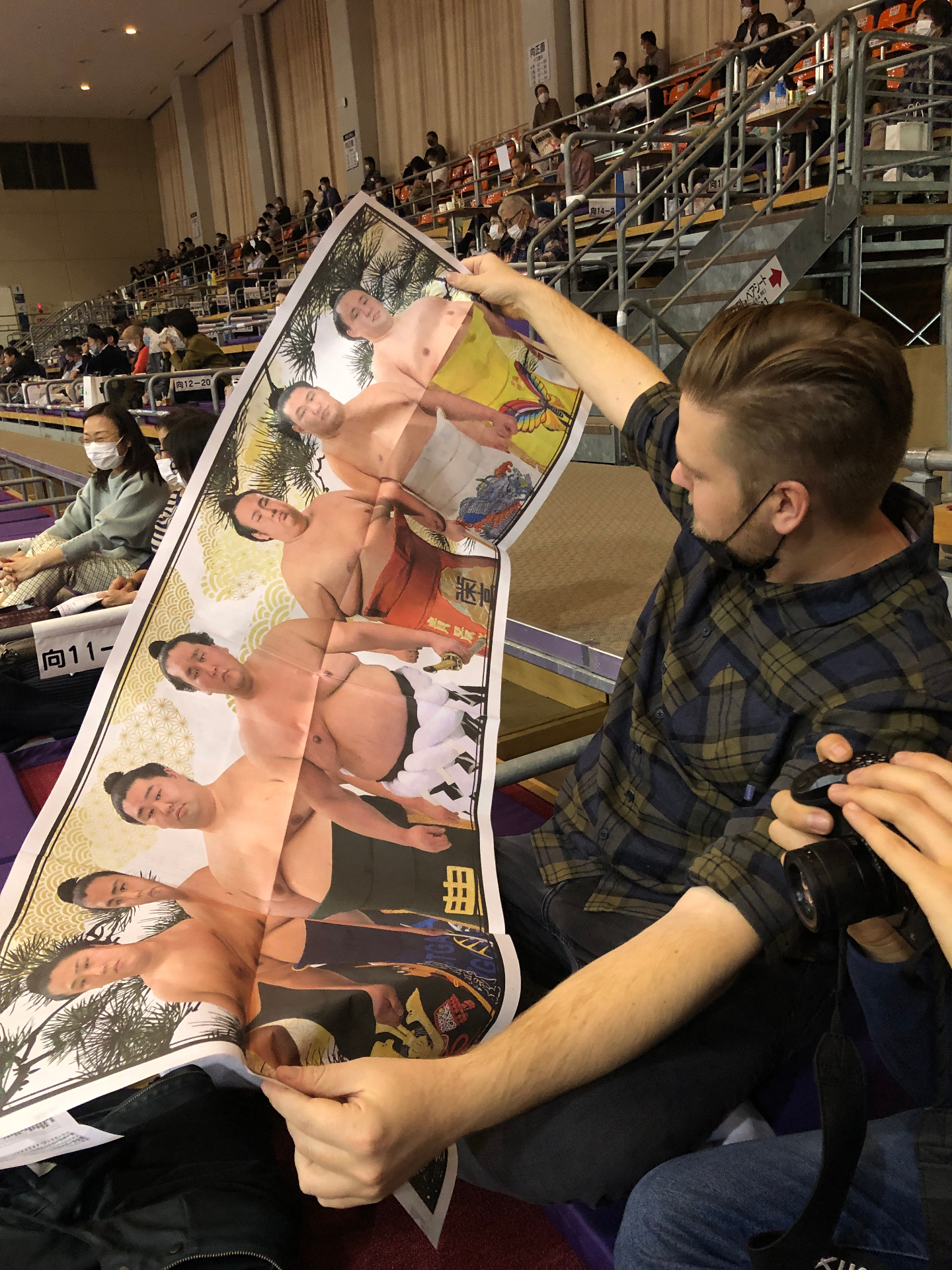 Sumo poster bestuderen tussen het publiek in Tokyo